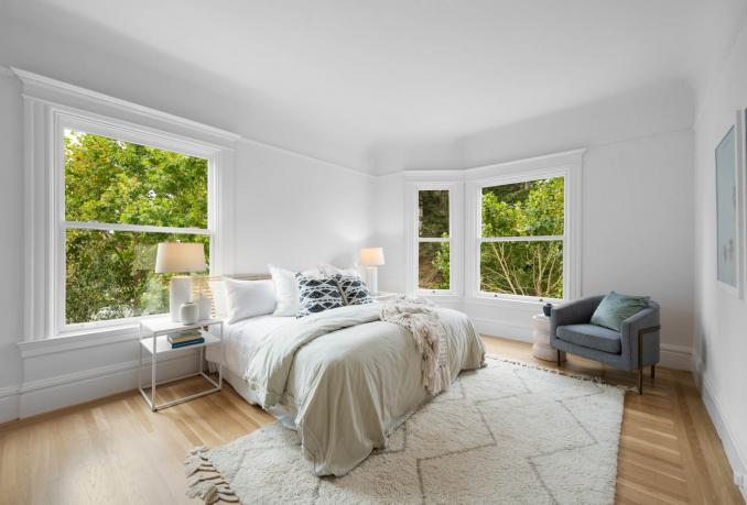 Property Thumbnail: Primary bedroom fits a kind bed and a nice plush chair. This room is on the front side of building so windows look out to Buena Vista Ave. 