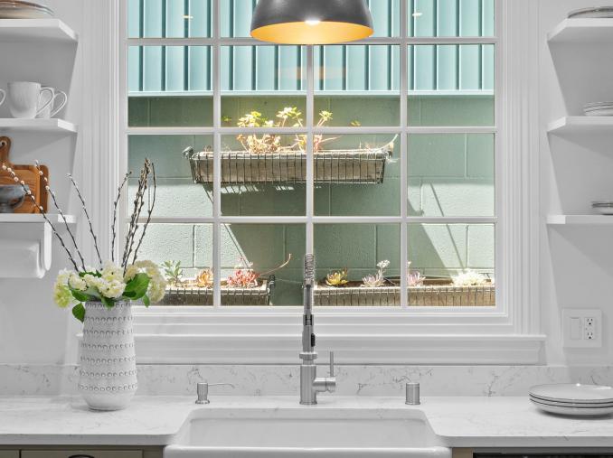 Property Thumbnail: Close up of the sink looking out the window. There are flower boxes with succulents.