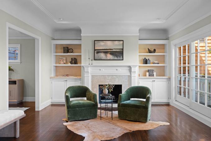 Property Thumbnail: The living room fireplace has built-ins on both sides. There is a juliet balcony to the left and dining room is to the left. 