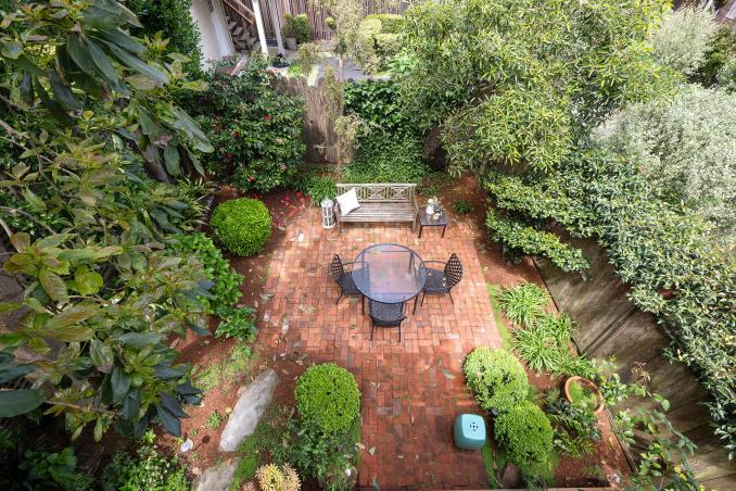 Property Thumbnail: Shared yard has lots of lush greenery and brick patio. 
