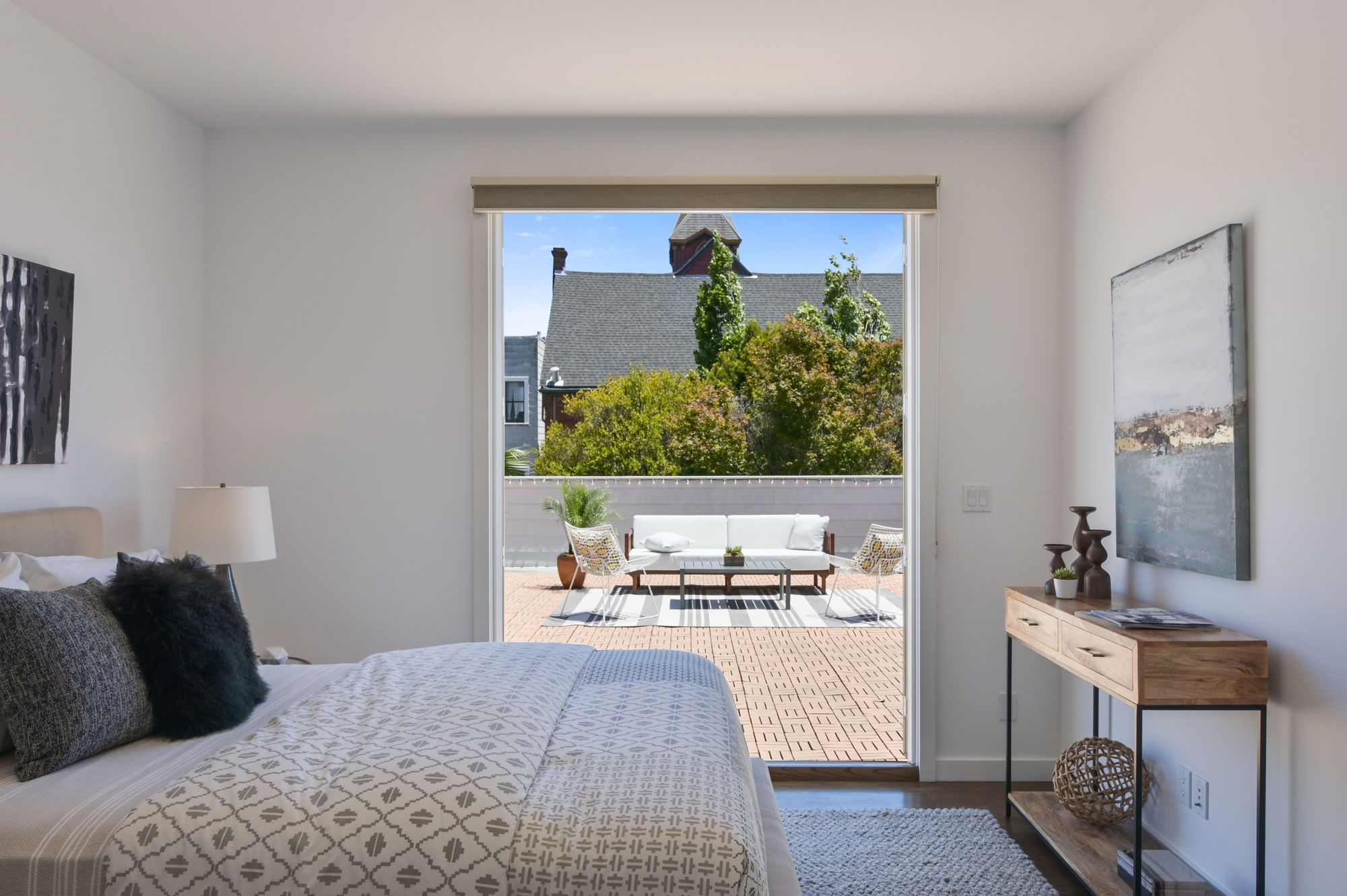 Property Photo: A shot looking over a bed, through open doors and out to the luxurious deck