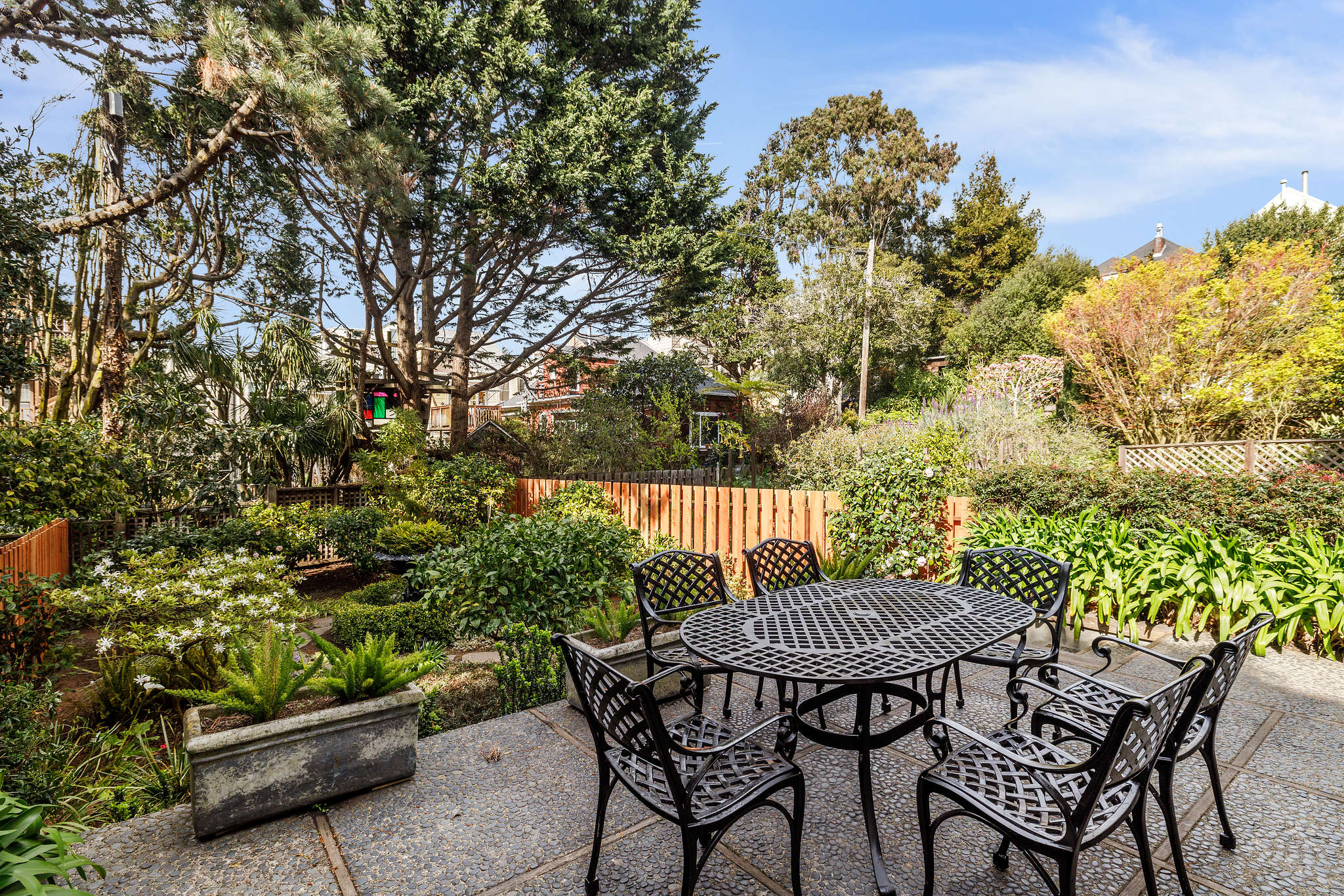 Property Photo: Out door dining area, with a view of a garden area and trees