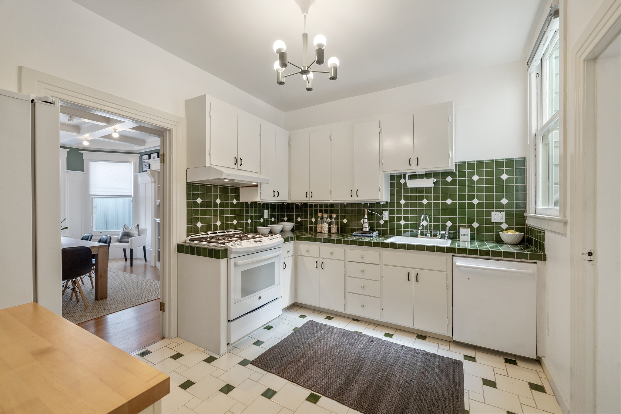 Property Photo: Kitchen, with green backsplash and white cabinets 
