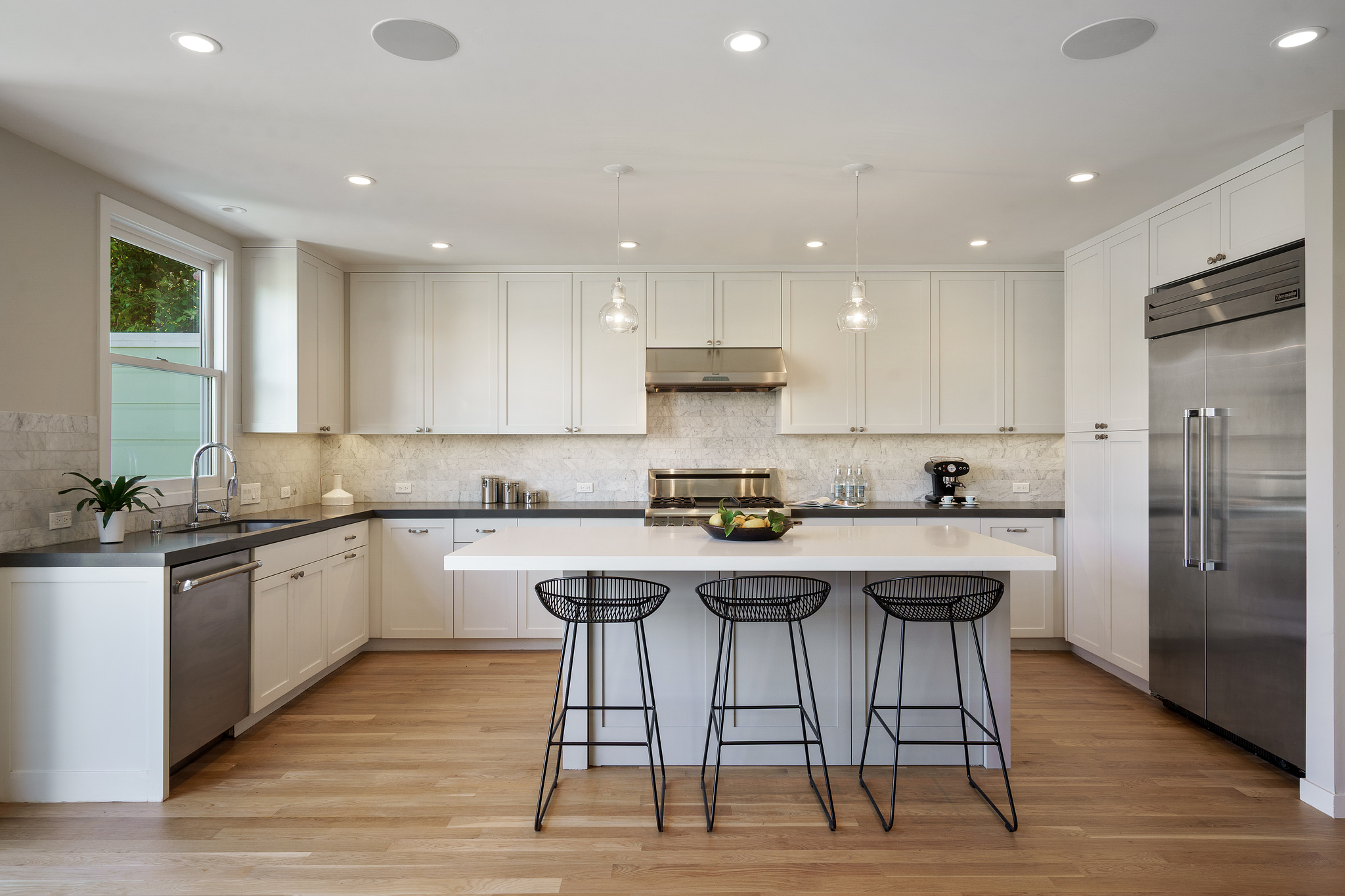 Property Photo: View of the kitchen, featuring white cabinets and stainless appliances