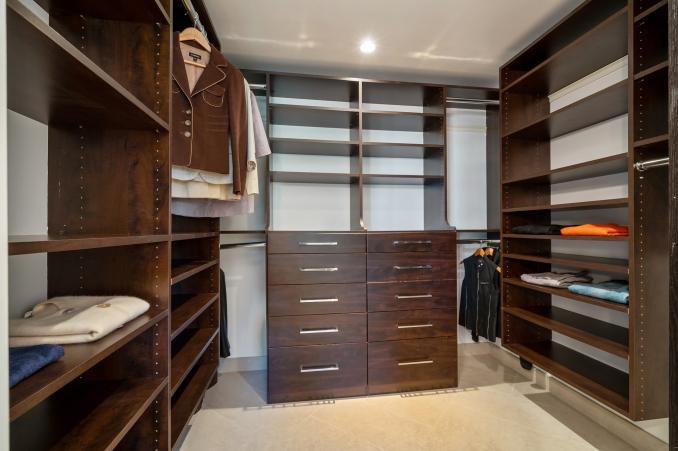 Property Thumbnail: Large walk-in closet with built-in wood shelving 