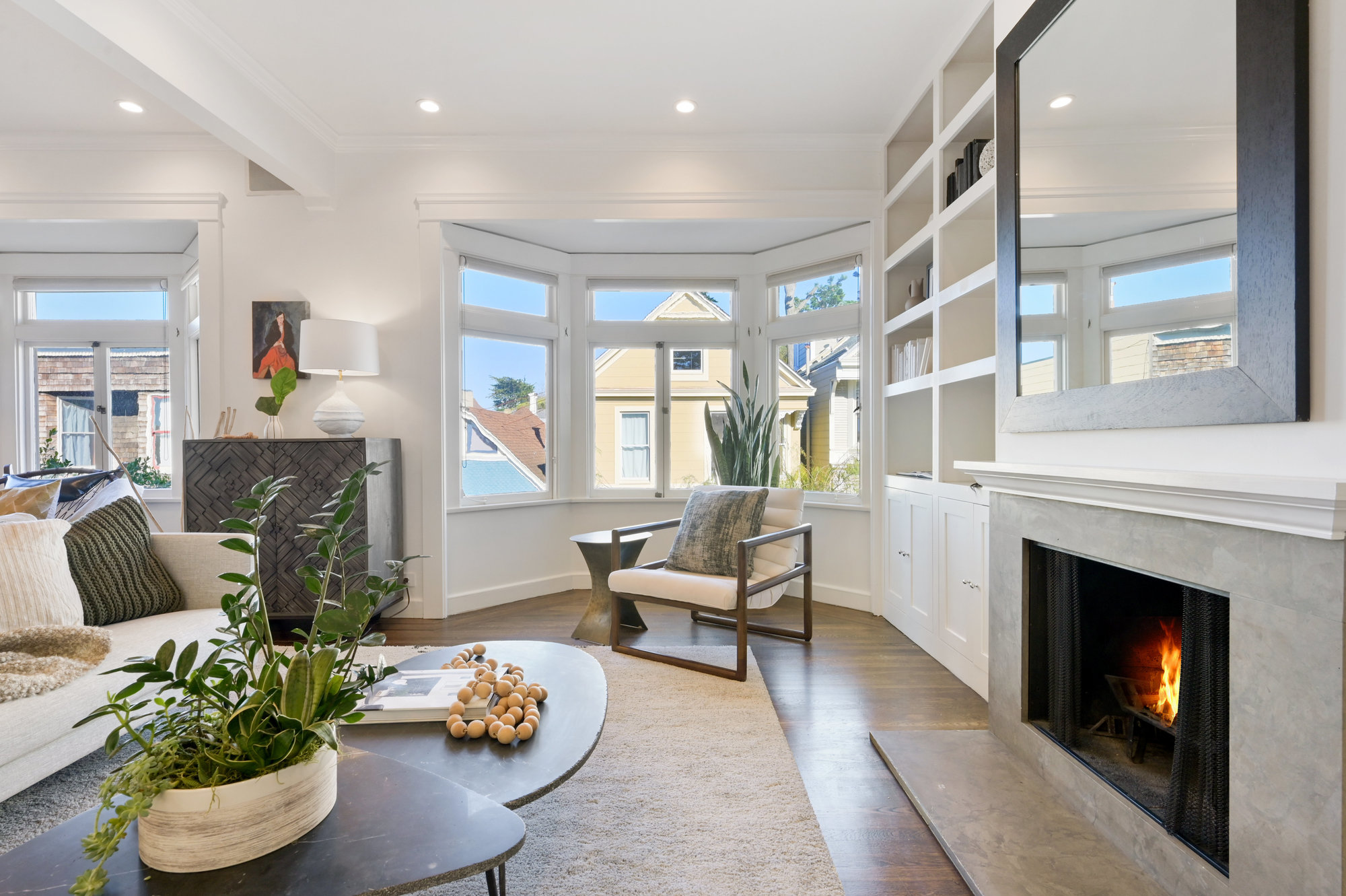 Property Photo: Long-view of the living room, showing a bay window and wood floors