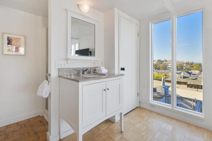 Property Thumbnail: Close-up of the sink and vanity, with a partial view of the city in the background