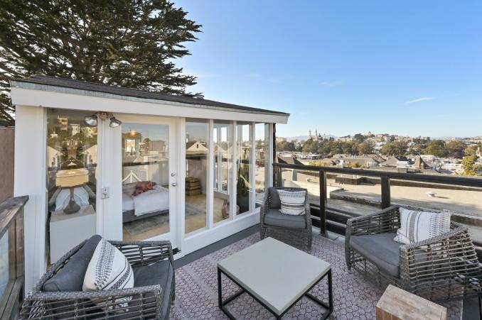 Property Thumbnail: A view of the third bedroom from the rooftop deck, showing a glass framed bedroom with the city in the background