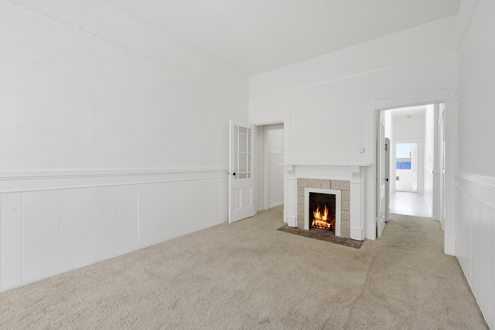 Property Photo: Side-view of the living room with a fireplace