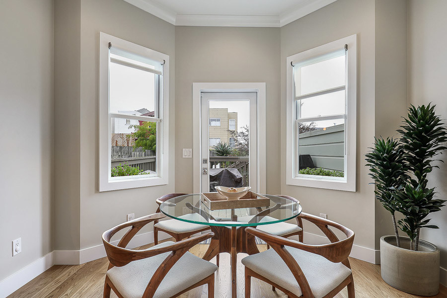 Property Photo: Close-up of the dining area, featuring two large windows and an exterior door