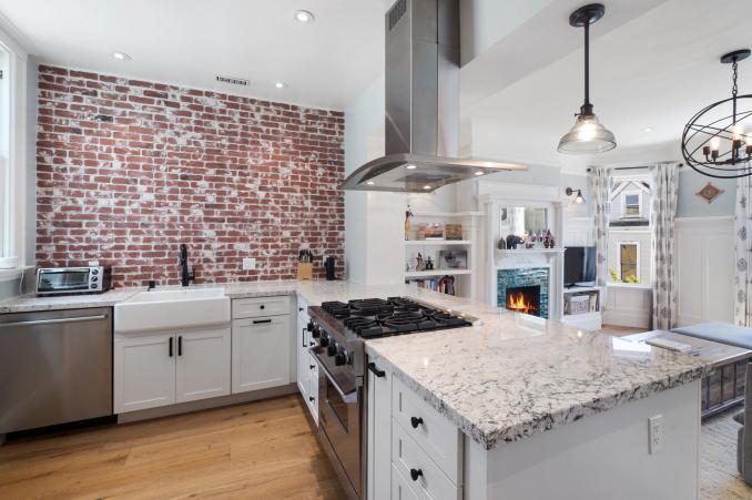 Property Thumbnail: Kitchen with exposed brick wall and large island with stove