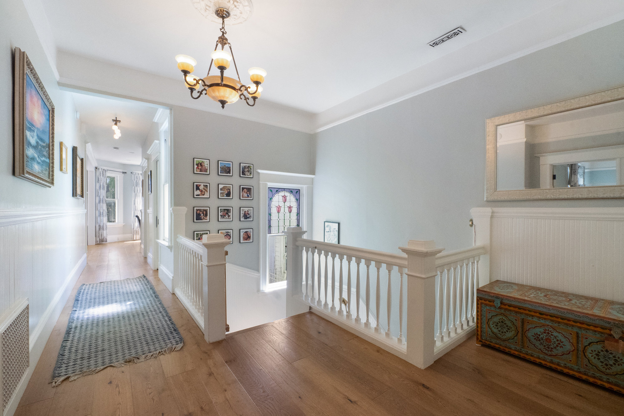 Property Photo: Hallway view of the white wood railing and vaulted stairwell 