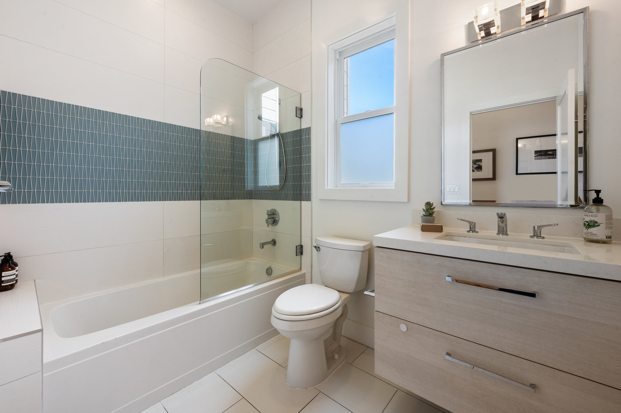 Property Photo: Bathroom with tile, partial glass tub, and single vanity