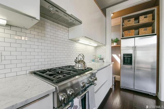 Property Thumbnail: View of a kitchen, featuring white tile backsplash and stainless appliances