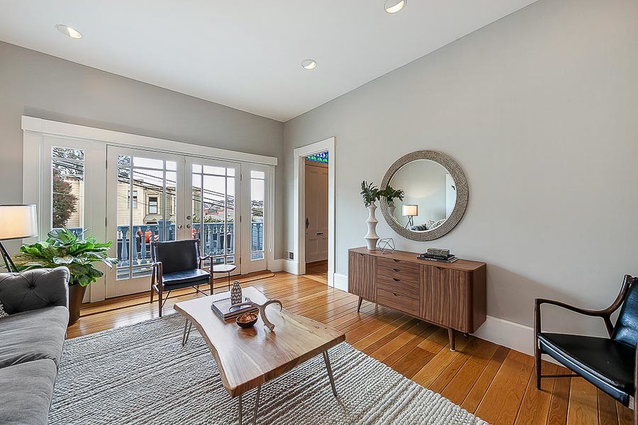 Property Photo: View of the living room, featuring wood floors and a large set of windows and glass exterior doors