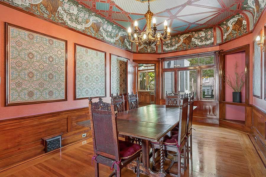 Property Photo: View of the formal dining room, featuring wood floors, intricate woodwork, and a chandelier 