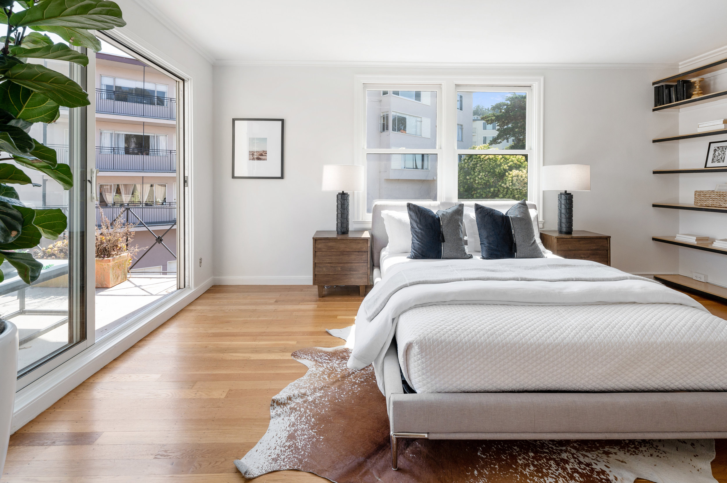 Property Photo: View of the second bedroom showing a large window and built-in shelves