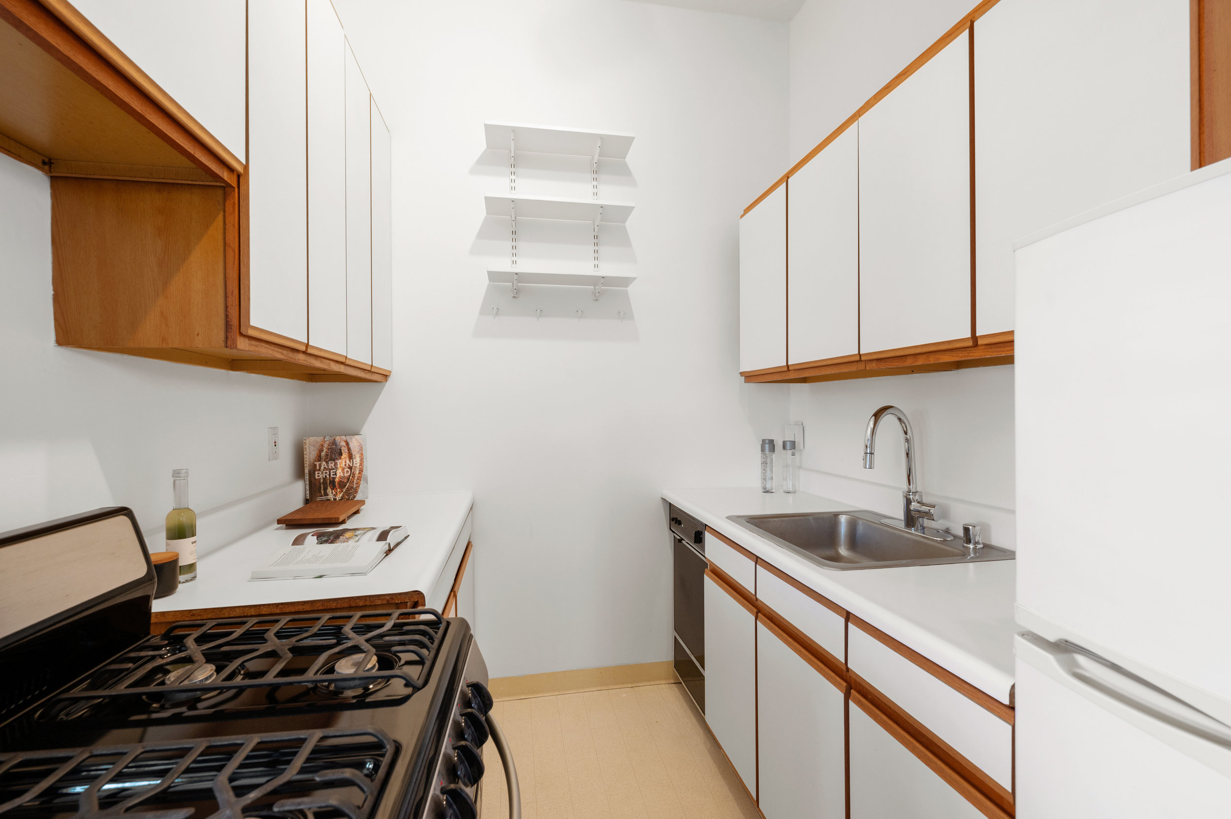 Property Photo: Lower level suite, showing the kitchen with cabinets, sink, fridge, and stove
