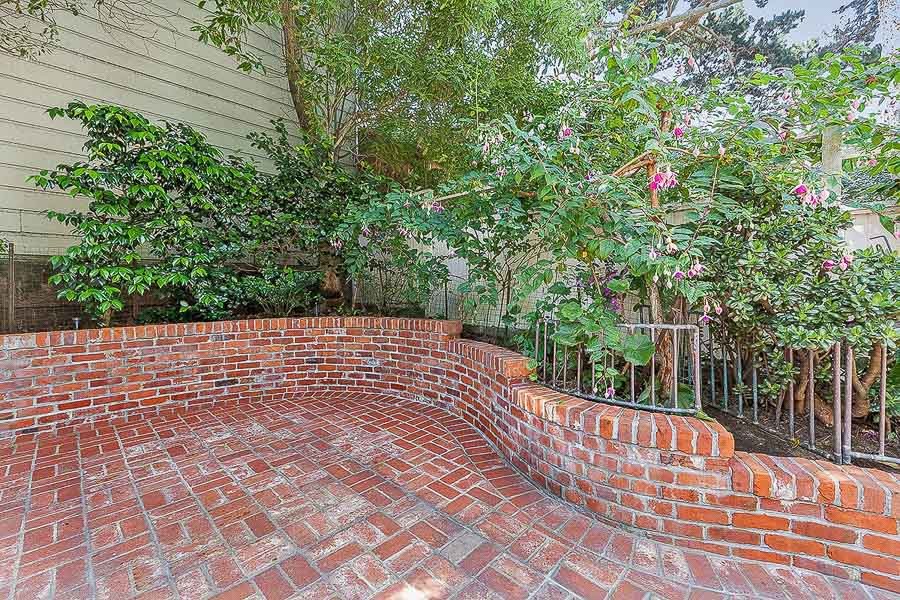Property Photo: Close-up view of the brick patio and surrounding plants