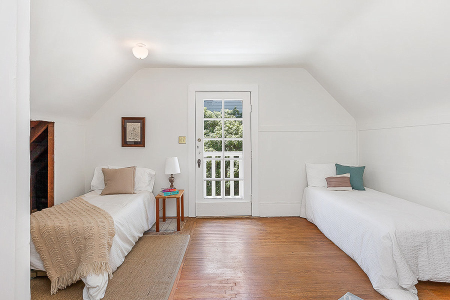 Property Photo: View of an upper-level bedroom with curved ceiling and an exterior door