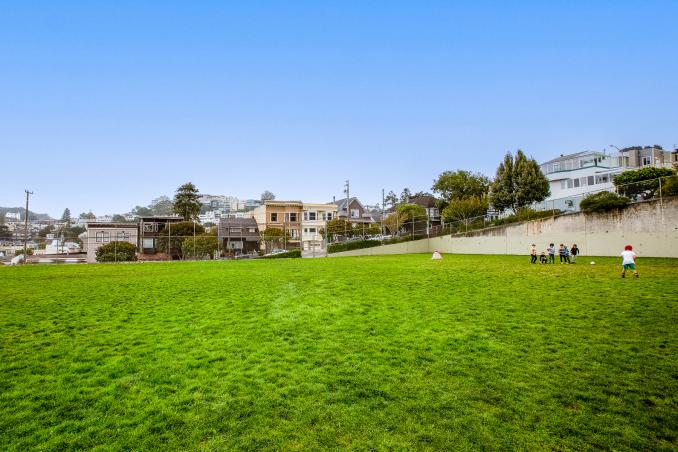 Property Thumbnail: A large green field with children playing at nearby Grattan Park