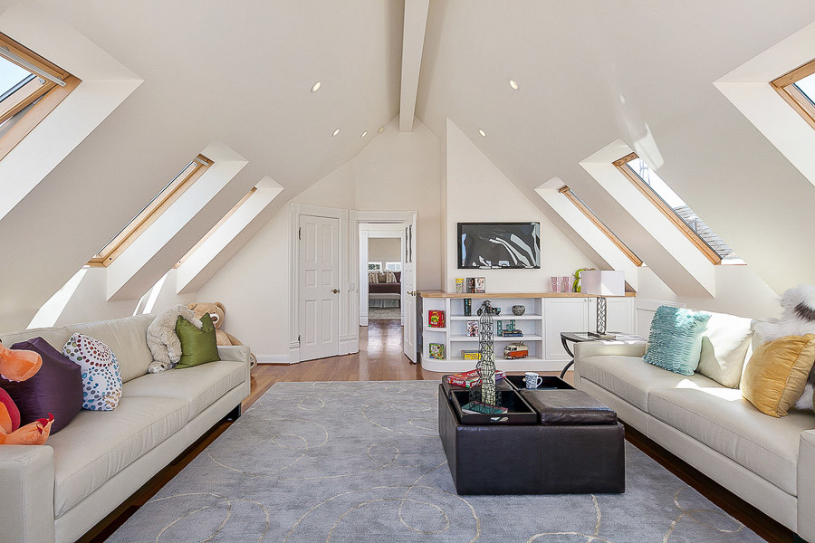 Property Photo: View of a large living area with slanted ceilings and six skylight windows 