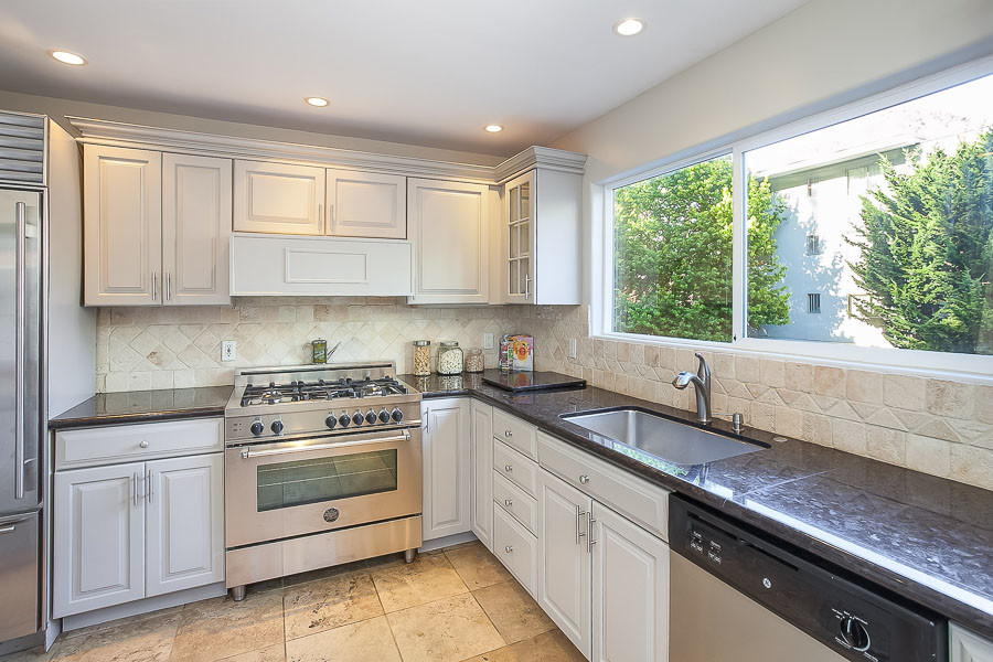 Property Photo: Kitchen, featuring tile floors and white cabinets 