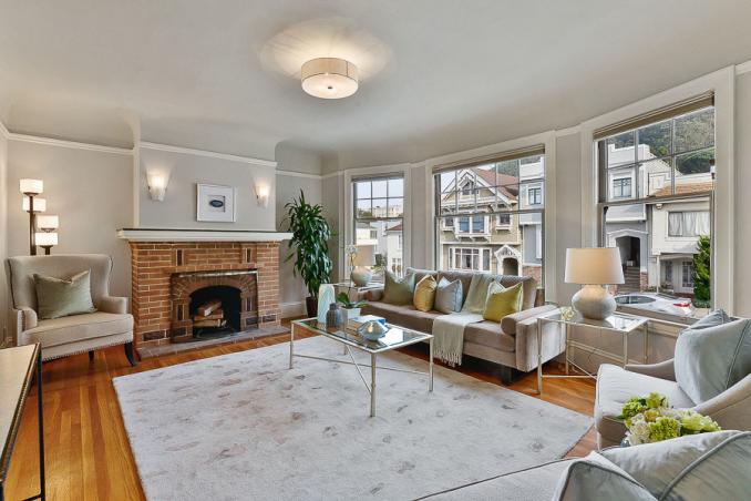 Property Thumbnail: View of the living room, featuring a brick fireplace and large windows