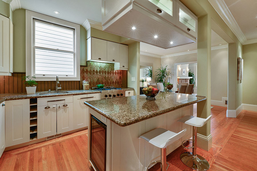 Property Photo: Kitchen with wood floors and an island with seating 