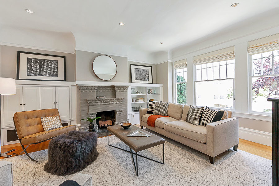 Property Photo: View of the living room, featuring large windows and a fireplace