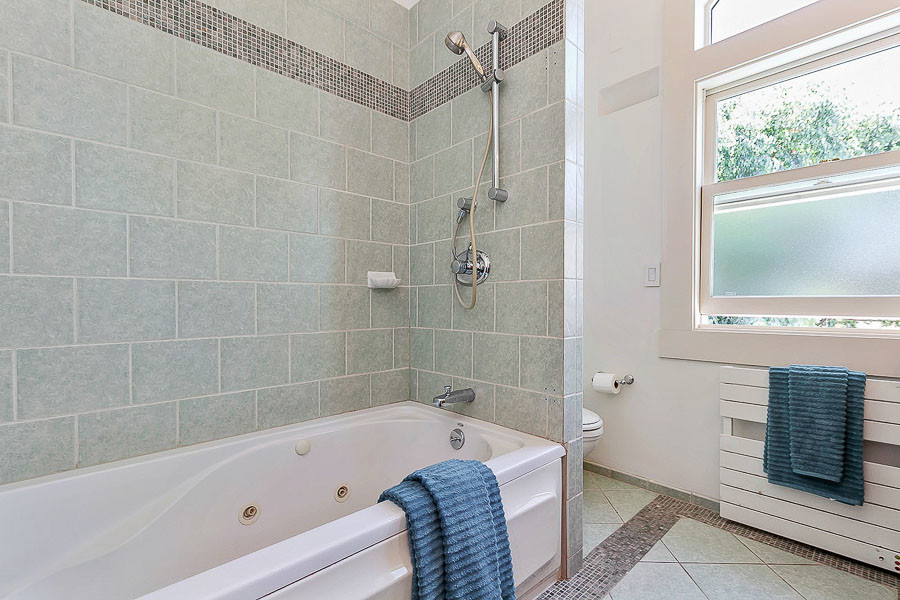 Property Photo: Bathroom with green/gray tiling 