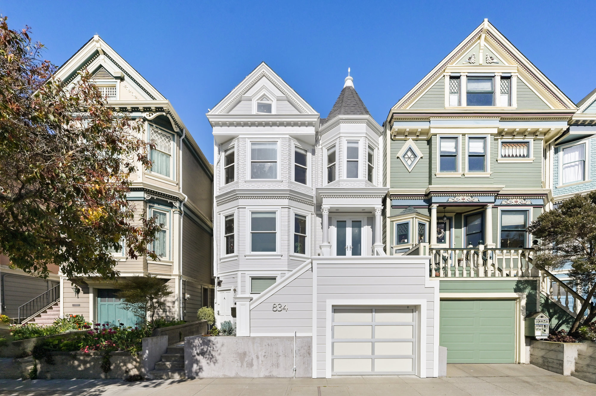 Front exterior view of 834 Clayton St, showing a pale grey Victorian home