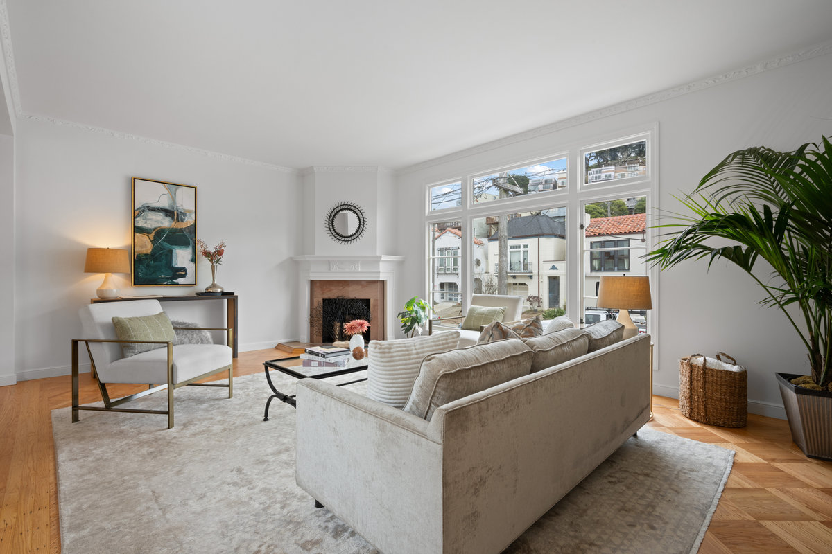 Living room with large windows that look out to 17th ave and let in lots of natural light.