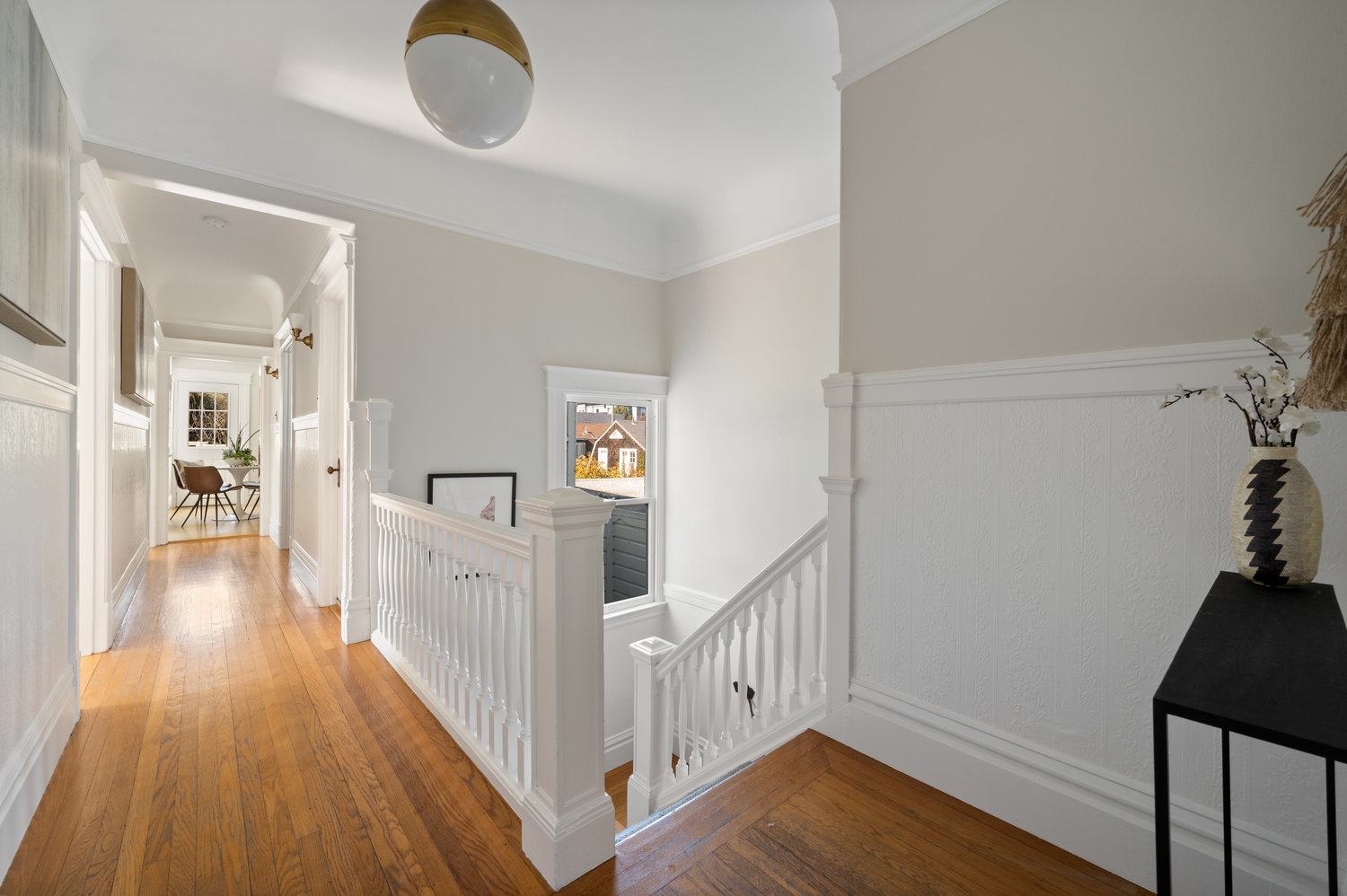 013photos1223shrader014 Hallway, featuring wood floors and a pretty white wood staircase leading down
