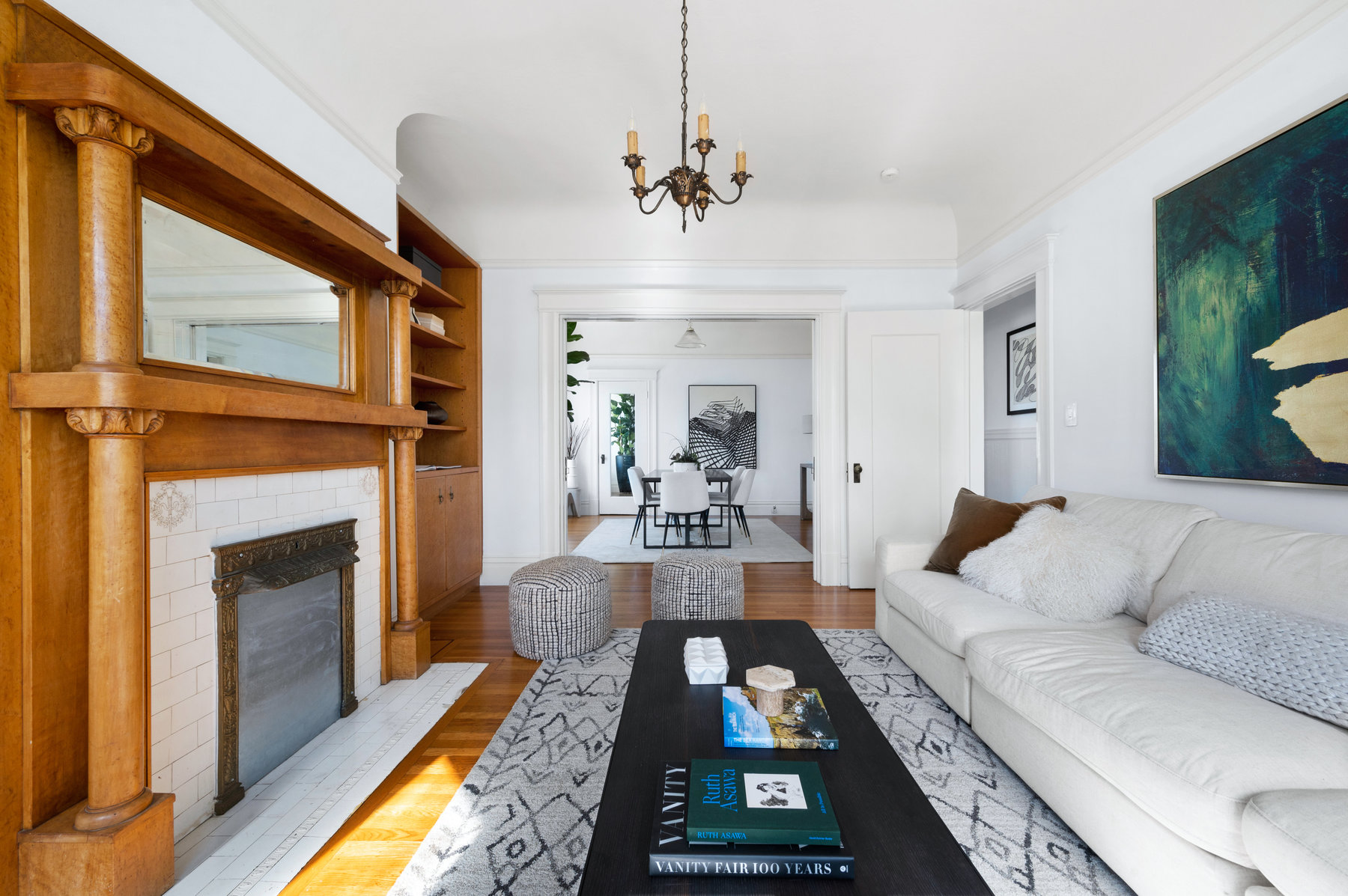 Front sitting room has large couch, fireplace, and hardwood floors throughout.