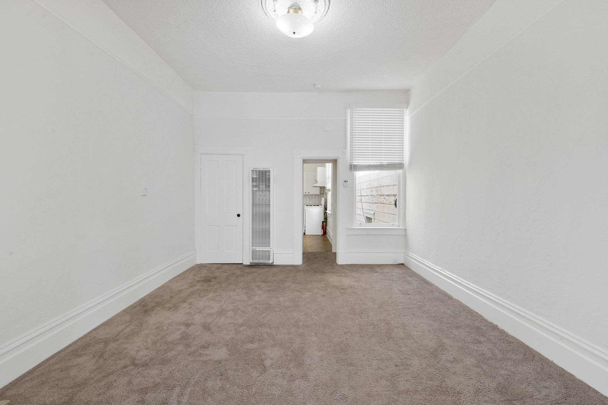 016017 View of a long room with carpeting and a window