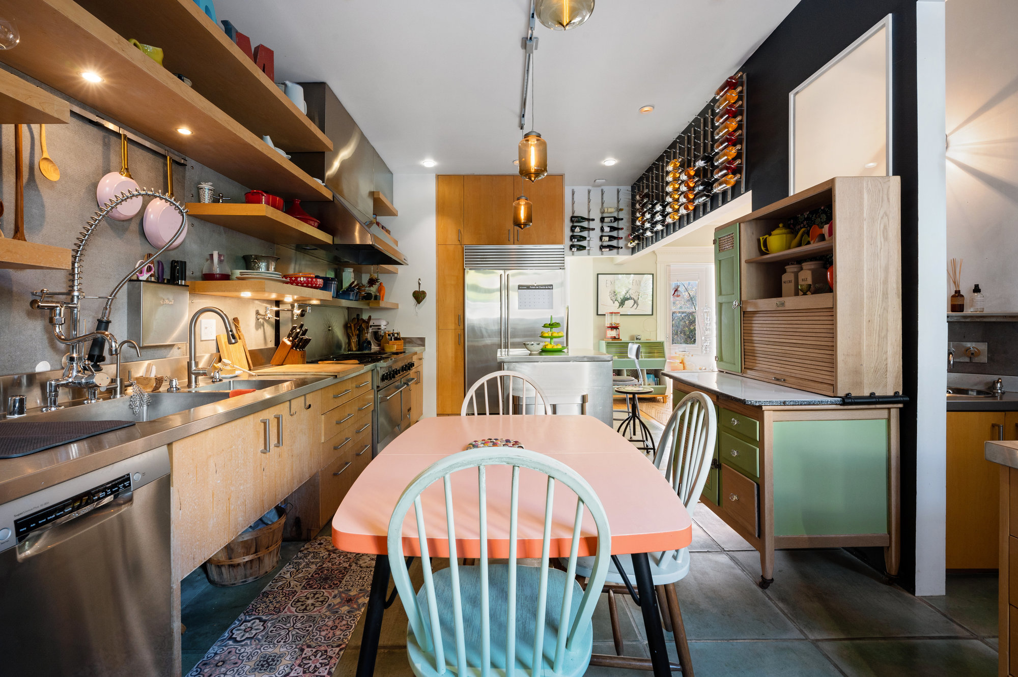 Kitchen with open shelving, pendant lights and an eat-in dining area