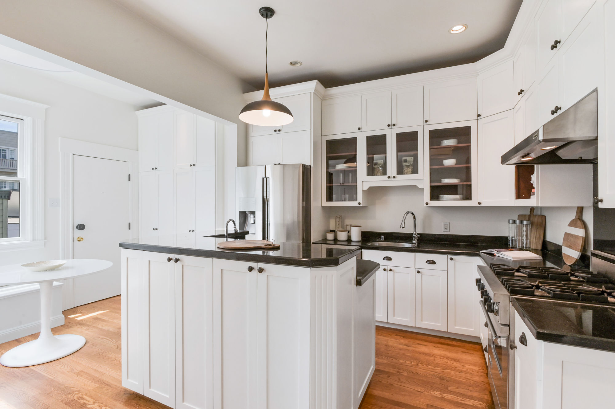 View of the kitchen, featuring white cabinets and wood floors
