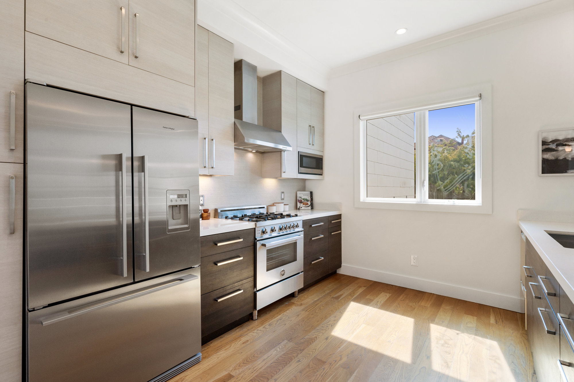 View of the kitchen, showing a large stainless refrigerator and window
