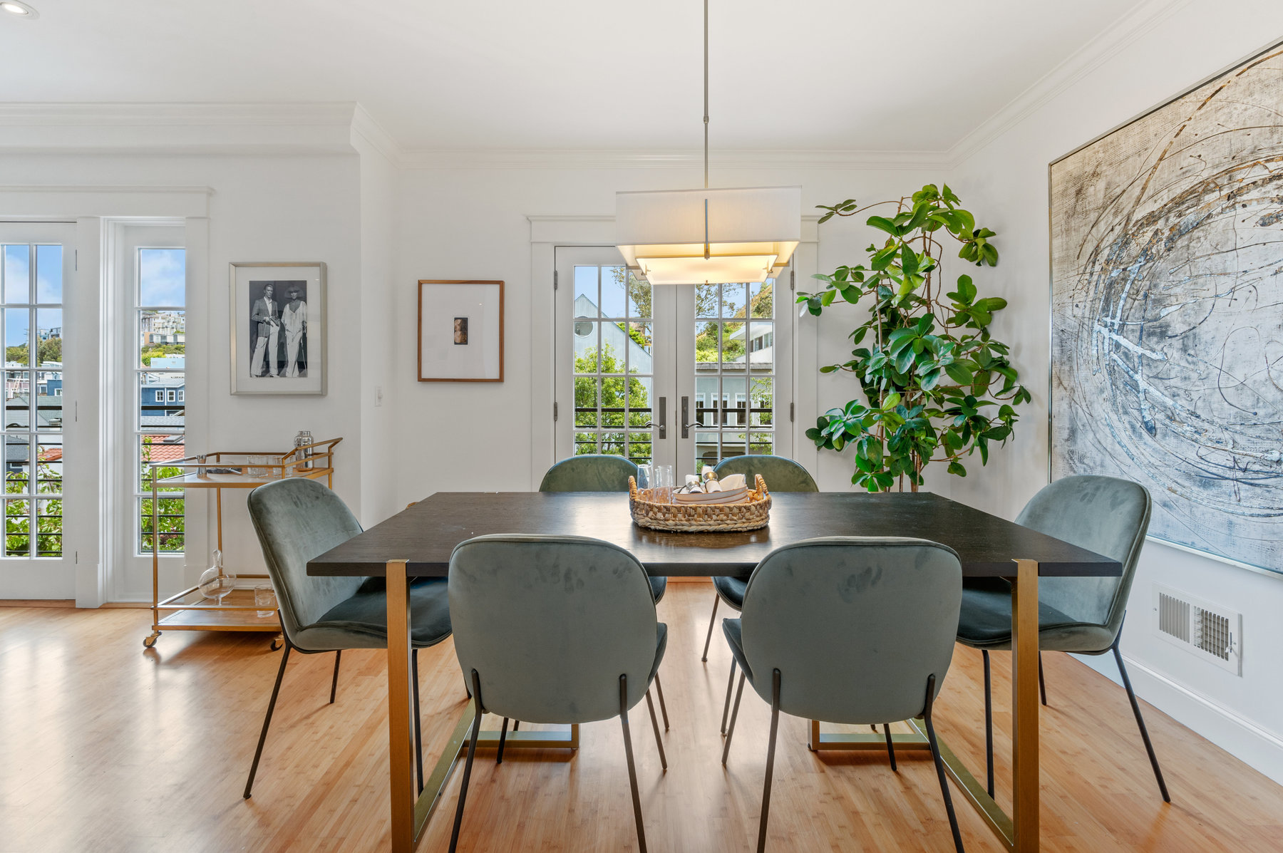 Photo of dining room with dining table centered and french doors looking out to Cole Street as backdrop.