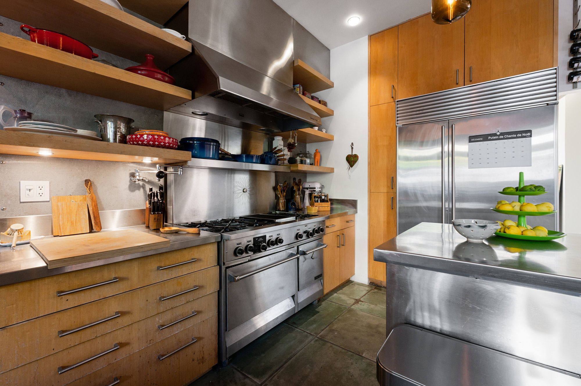 View of the cooking area, showing a large stainless steel range and oversized fridge and island