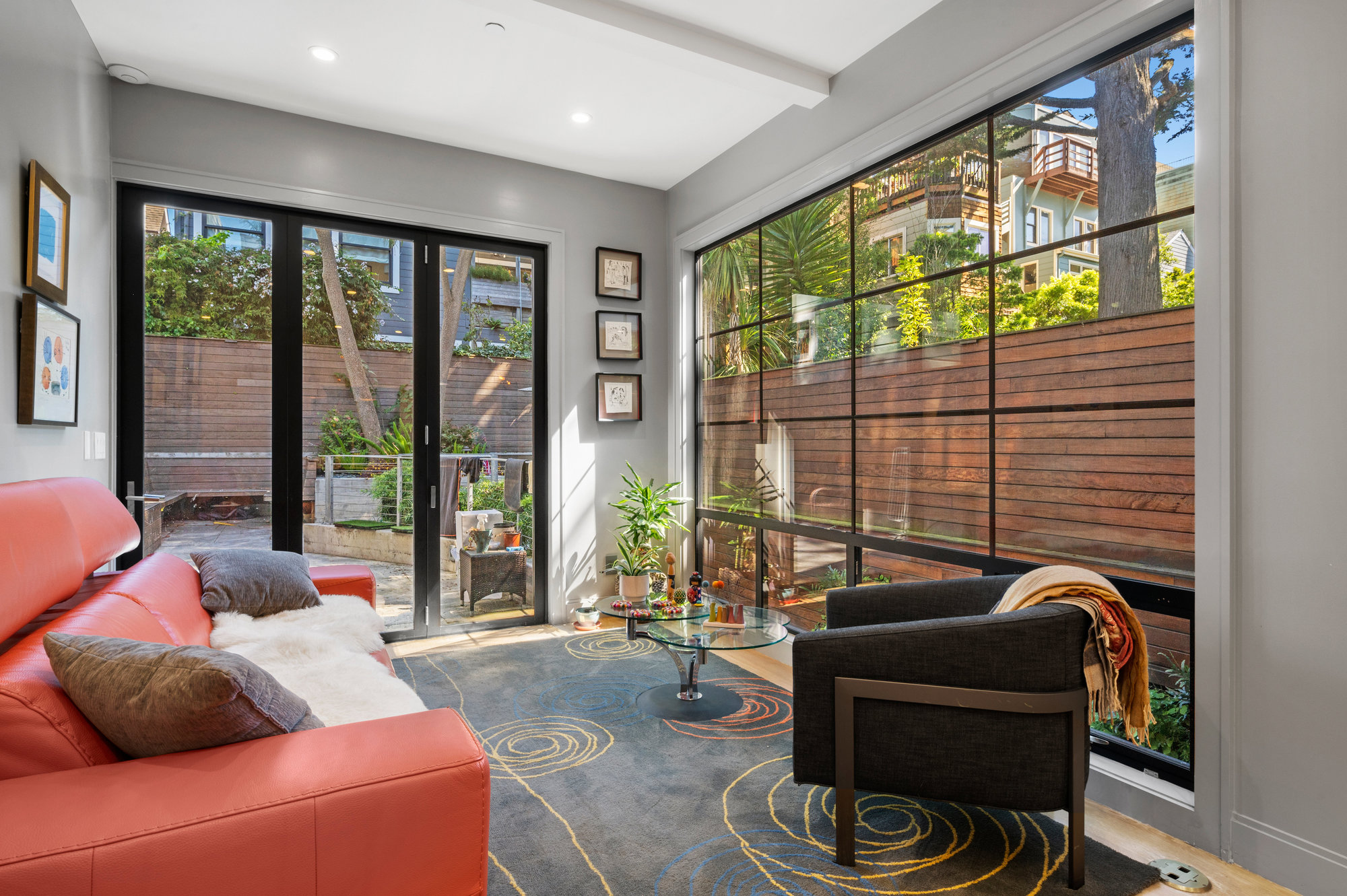 Looking out over couch in living room to windows that look out to back yard.