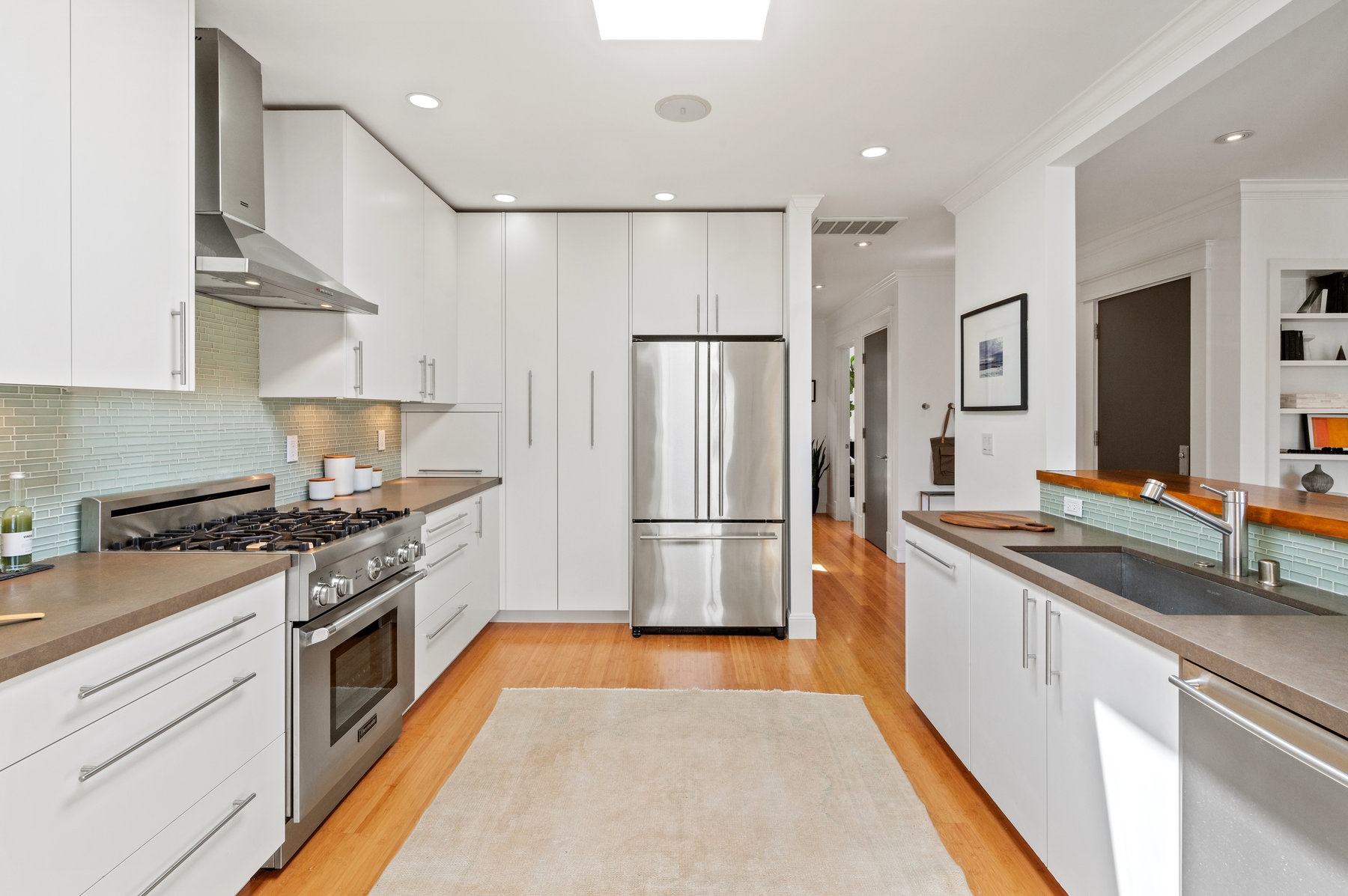 Kitchen from dining room. All stainless steel appliances with all white cabinetry.