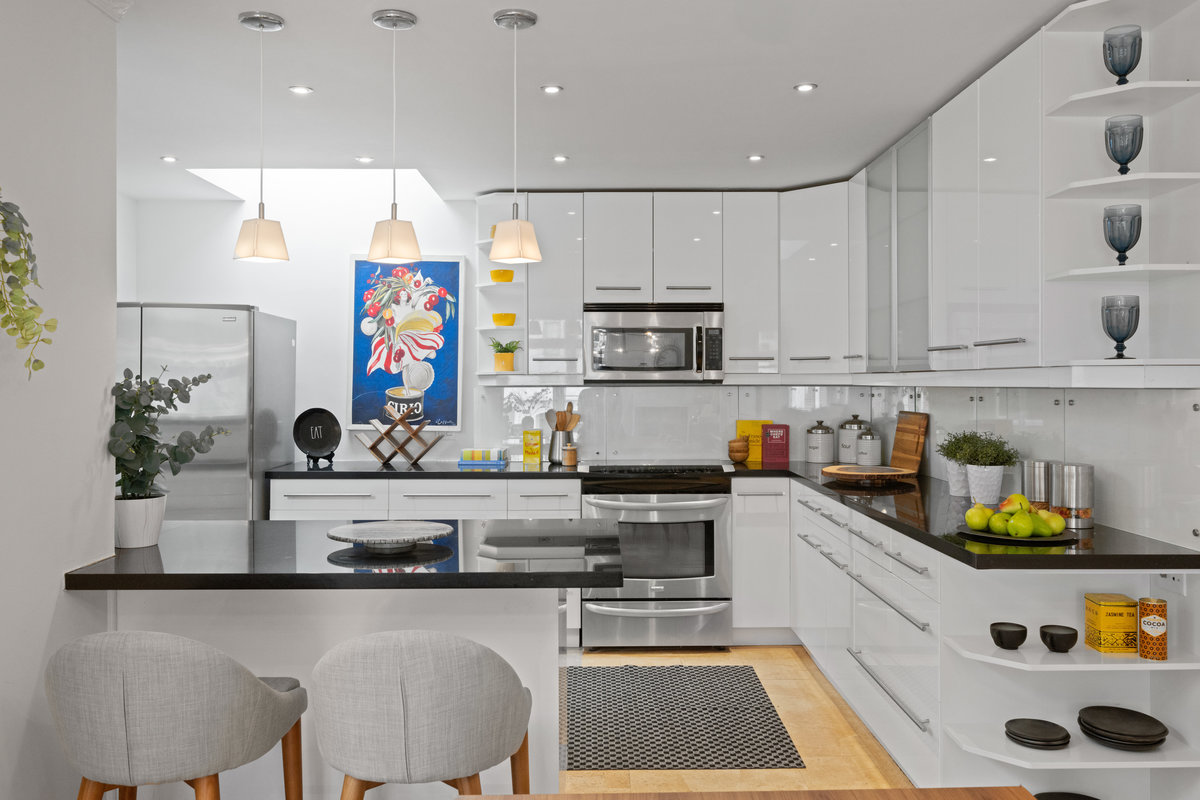 Kitchen is recently updated with stainless steal appliances. The cabinets are white and countertops are dark stone.
