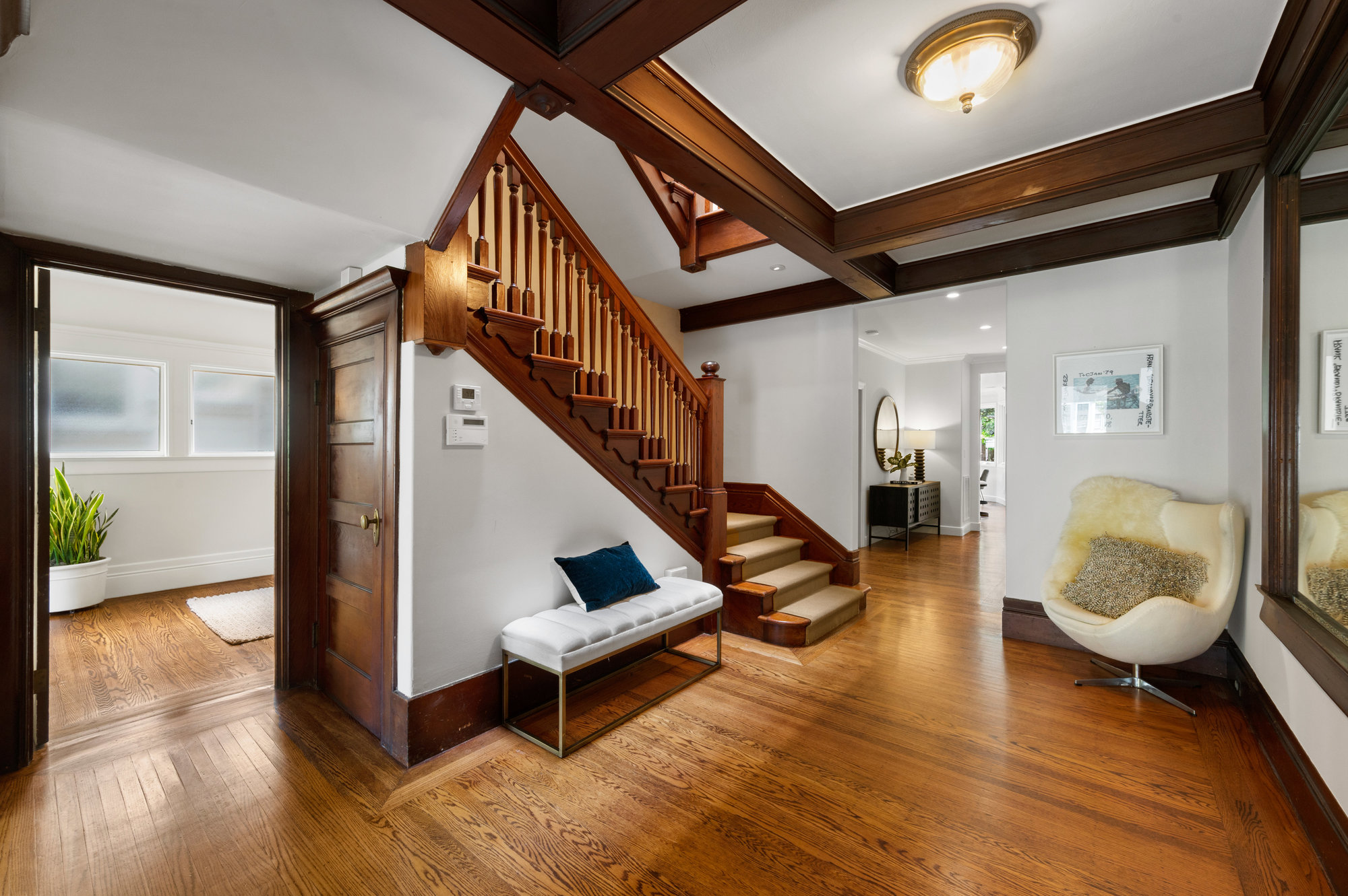 Front entry, showing wood floors and a large wood staircase