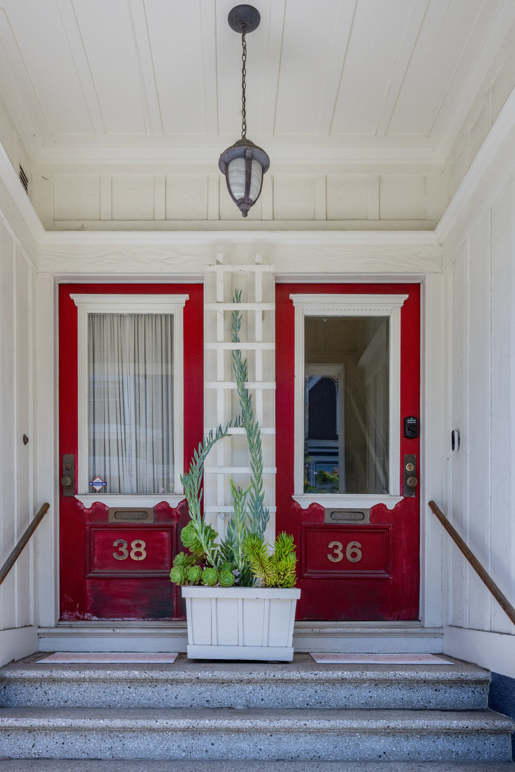 025photos36almaext005781 Front entryway. There is a small staircase that leads up to the doorway. There is red door.