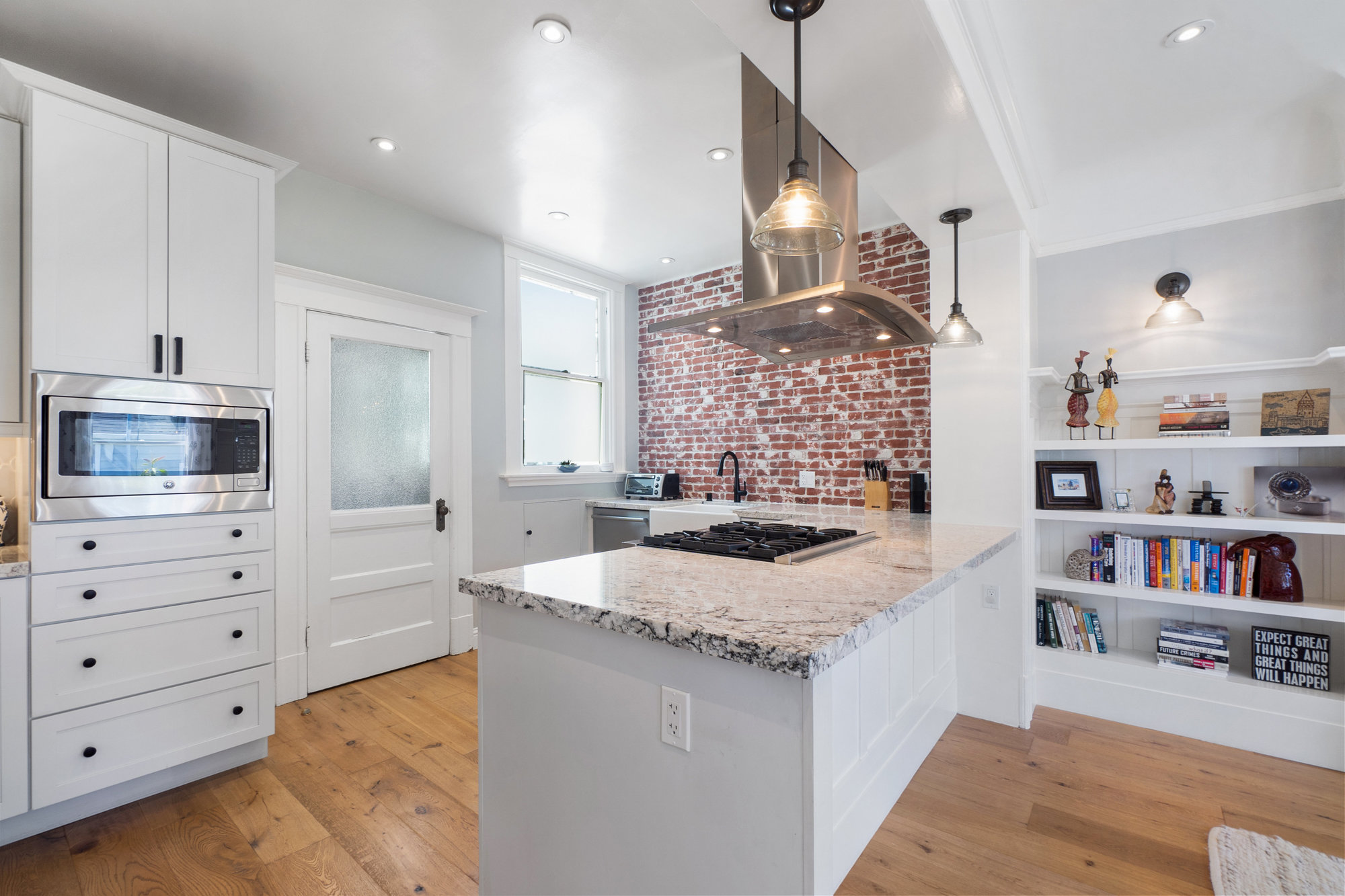 026024 Kitchen with wood floors, white cabinets, and recess and pendant lighting