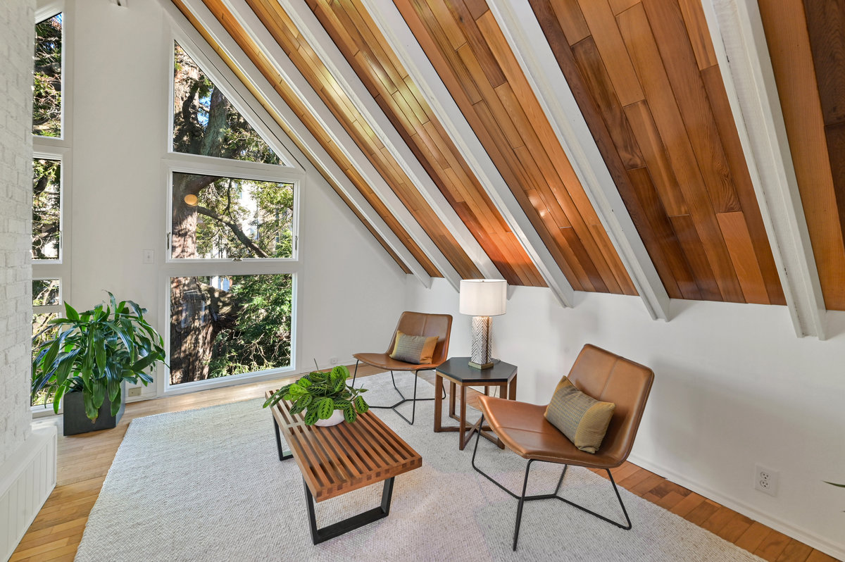 027043 Top-floor living space with slanted exposed wood ceilings