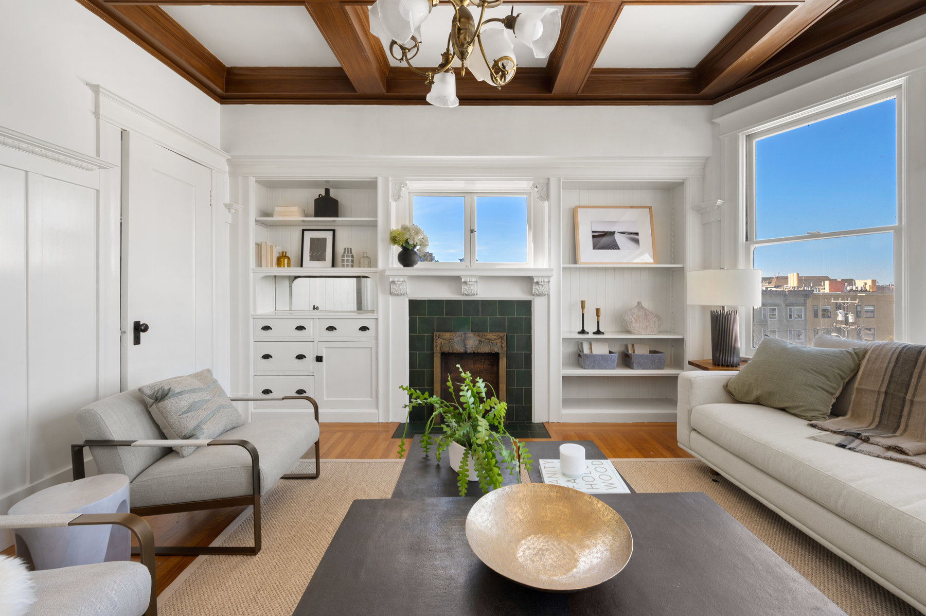 Back living room has built ins on both sides on fireplace. There is a window above fireplace that looks out to Cole Valley.