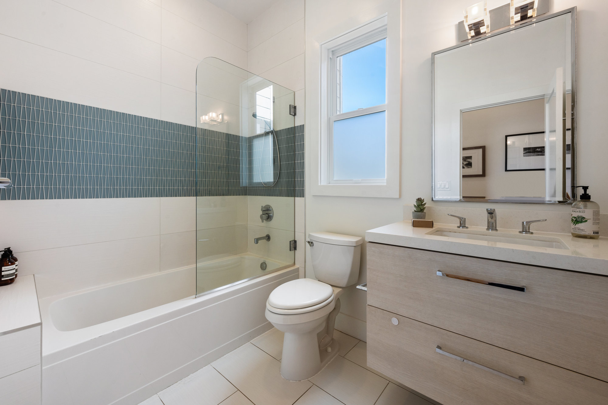 Bathroom with tile, partial glass tub, and single vanity